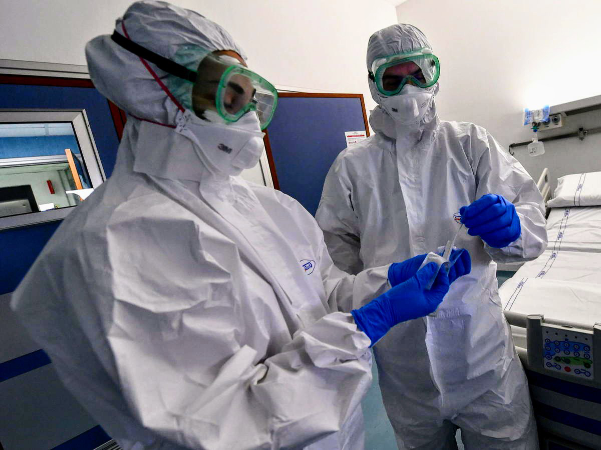 Enfermera y enfermero manejan una prueba de COVID-19