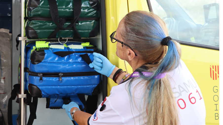 Enfermera de urgencias saca una maleta de la ambulancia