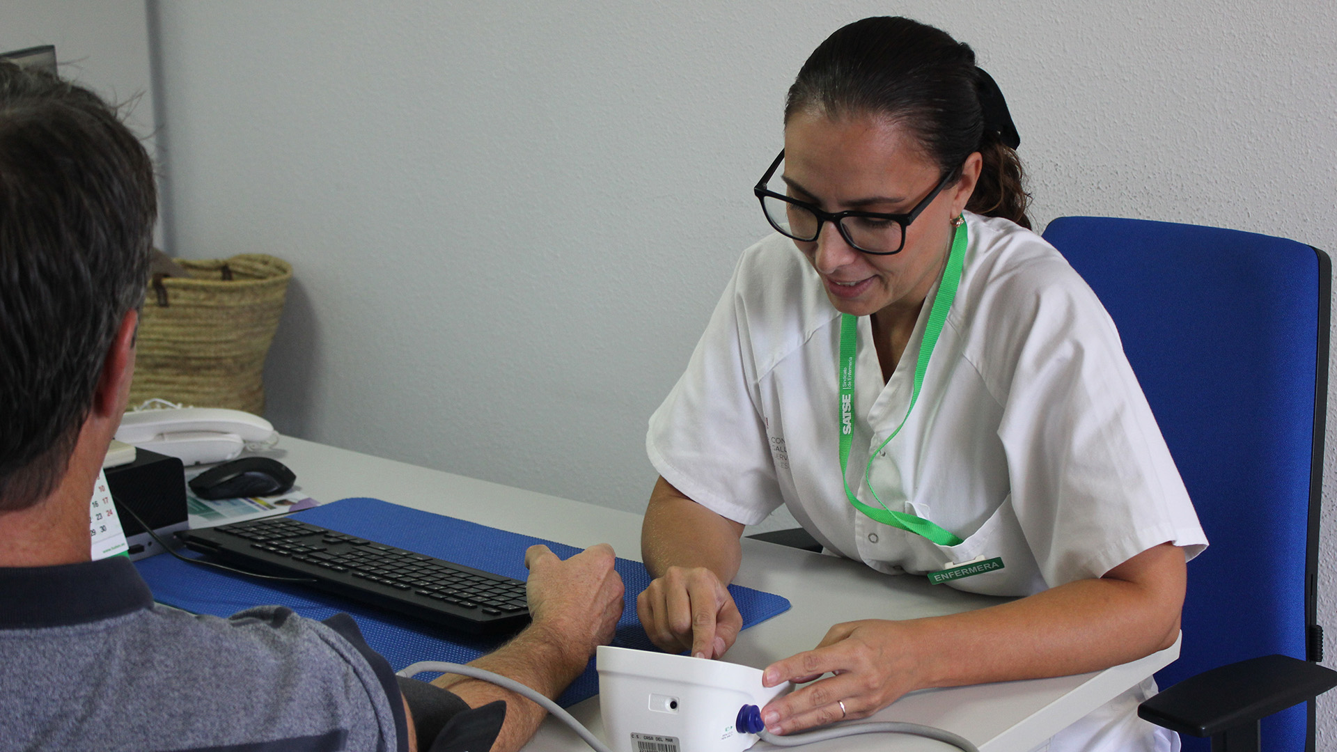 Enfermera toma la tensión paciente en un centro de salud