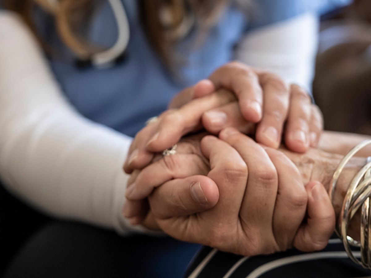 Enfermera de salud mental coge de la mano a una paciente